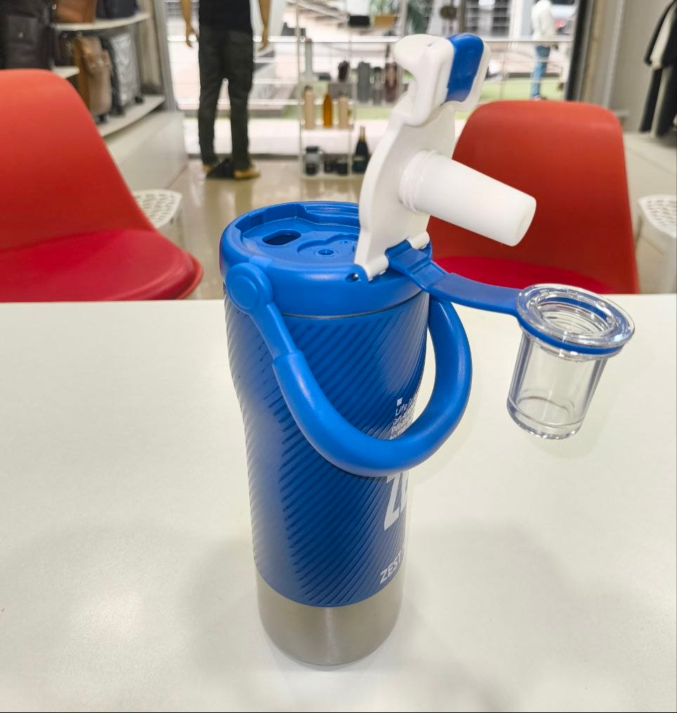 Blue and white bottle opener on a table with a store interior in the background